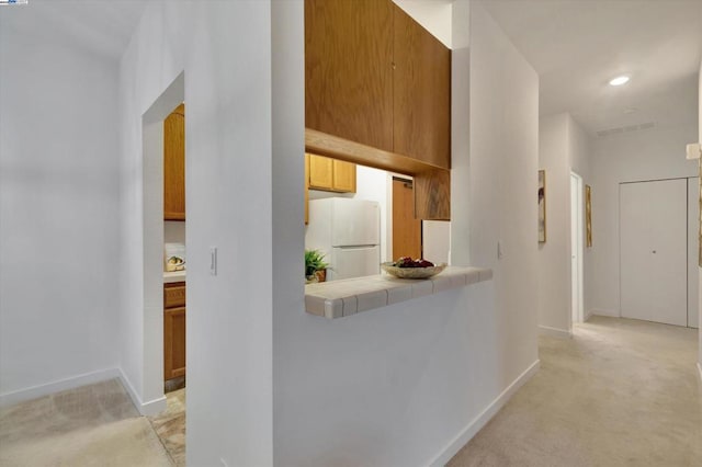 hallway featuring light colored carpet