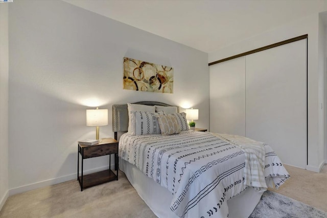 bedroom featuring light colored carpet and a closet