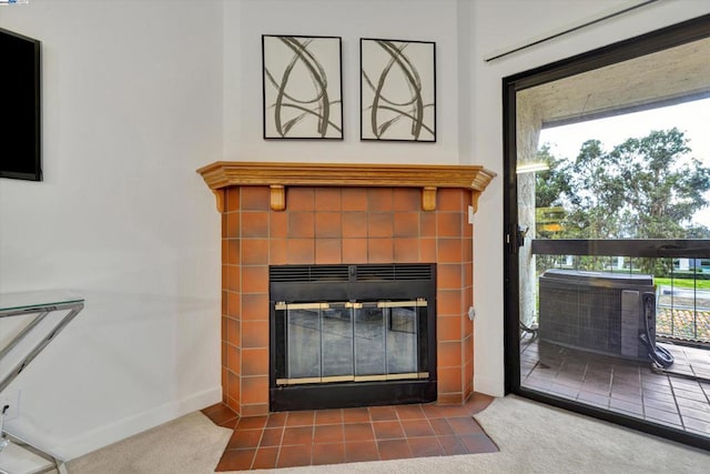 interior details featuring a tile fireplace, carpet, and central AC