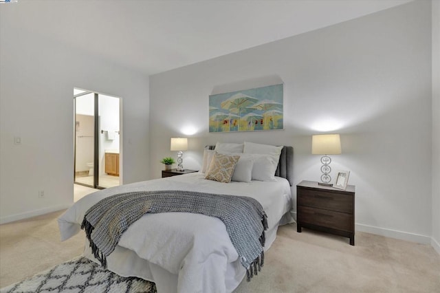 bedroom featuring ensuite bathroom and light carpet