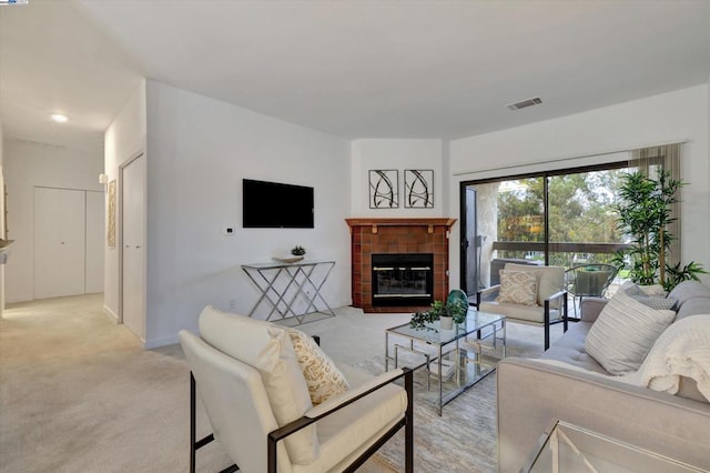 living room featuring a tiled fireplace and light colored carpet