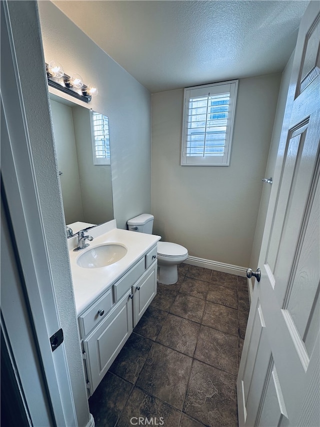 bathroom with vanity, a textured ceiling, and toilet