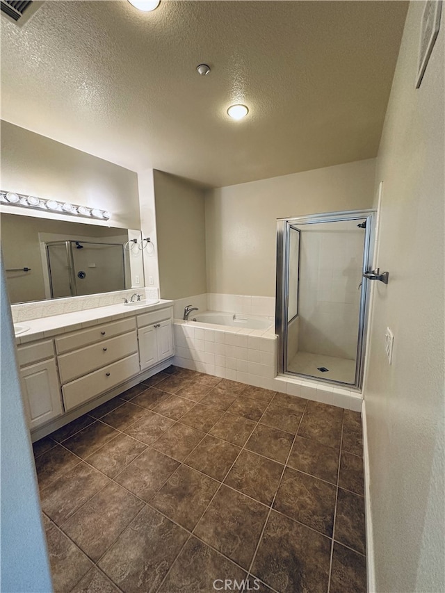 bathroom with vanity, a textured ceiling, and plus walk in shower