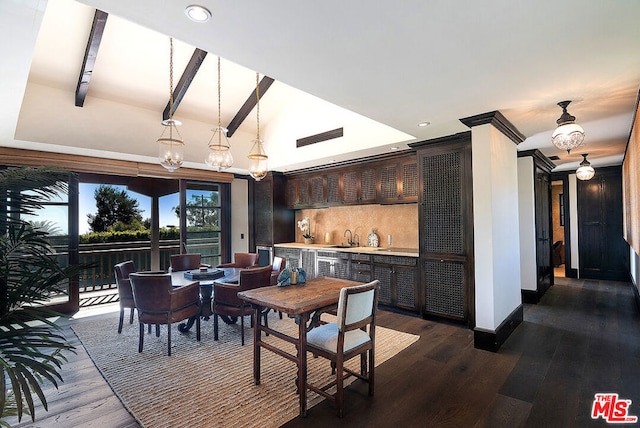 dining area with dark hardwood / wood-style flooring, wet bar, and lofted ceiling