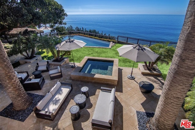 view of pool with a water view, a jacuzzi, a fire pit, and a patio area