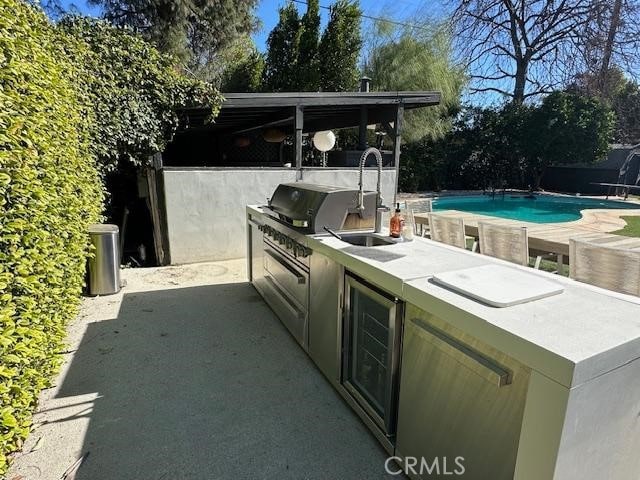 view of patio / terrace featuring exterior kitchen and beverage cooler