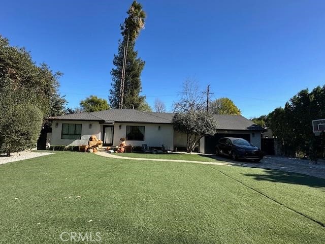 ranch-style house featuring a garage and a front lawn