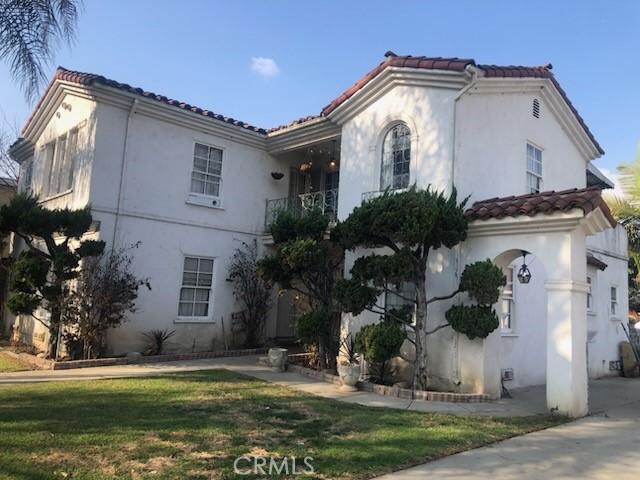 mediterranean / spanish-style home featuring a front yard and a balcony