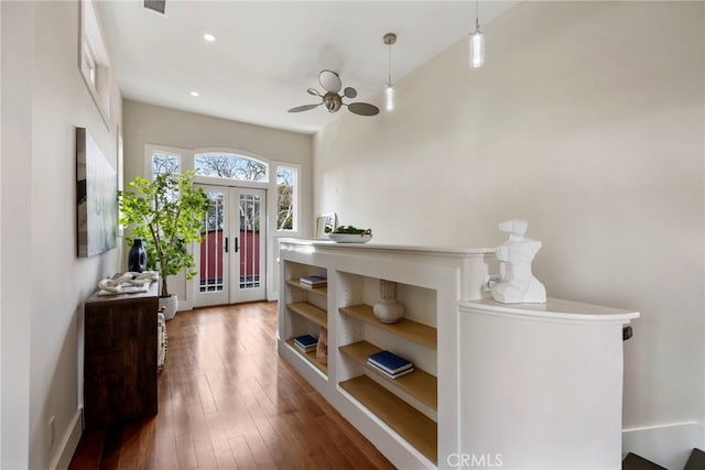 foyer entrance with dark hardwood / wood-style floors, ceiling fan, and french doors