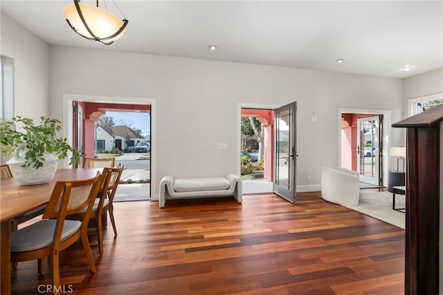 dining area with a healthy amount of sunlight and dark hardwood / wood-style flooring