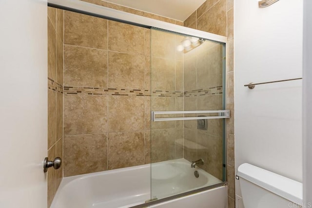 bathroom featuring enclosed tub / shower combo and toilet