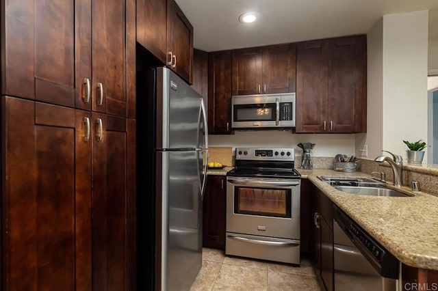 1775 Diamond Unit 308, Pacific Beach San Diego, CA 92109 - kitchen with appliances with stainless steel finishes, a sink, light tile patterned flooring, light stone counters, and dark brown cabinetry