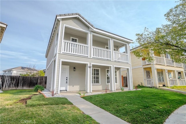 view of front of house with a front yard and a balcony