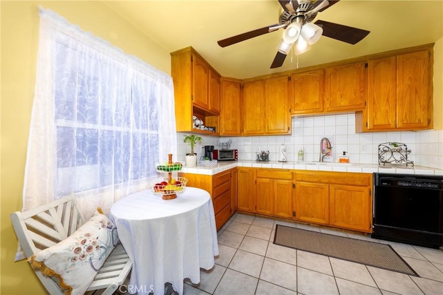 kitchen with sink, light tile patterned floors, tile counters, dishwasher, and backsplash