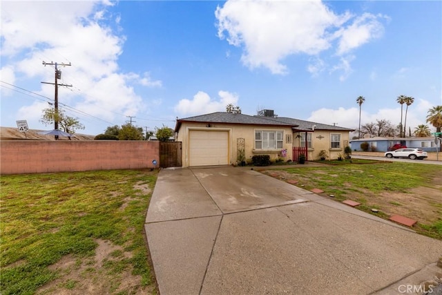 single story home featuring a garage and a front yard