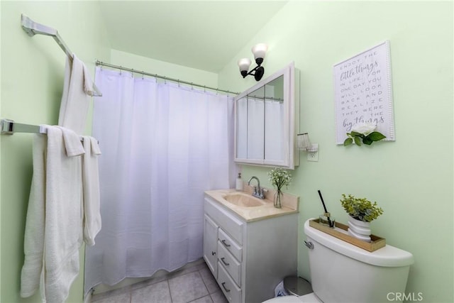 bathroom featuring walk in shower, vanity, toilet, and tile patterned flooring