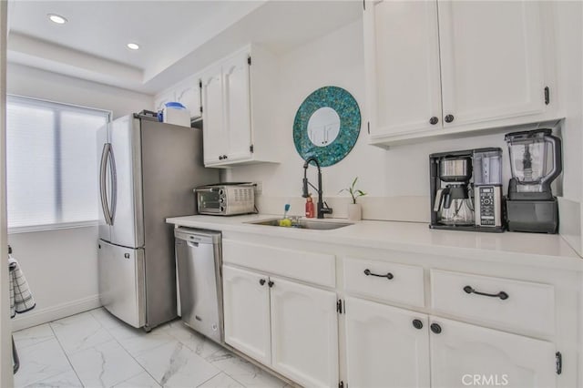 kitchen with stainless steel appliances, white cabinetry, and sink