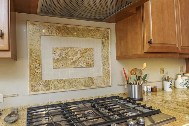 interior details featuring gas stovetop, tasteful backsplash, and wall chimney exhaust hood