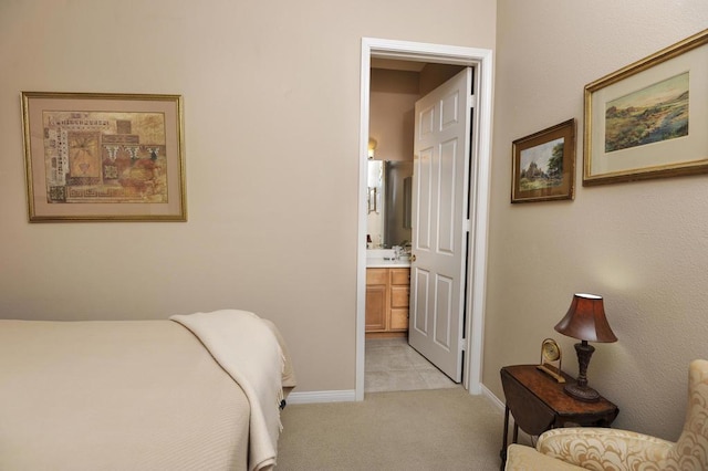 bedroom with connected bathroom and light carpet