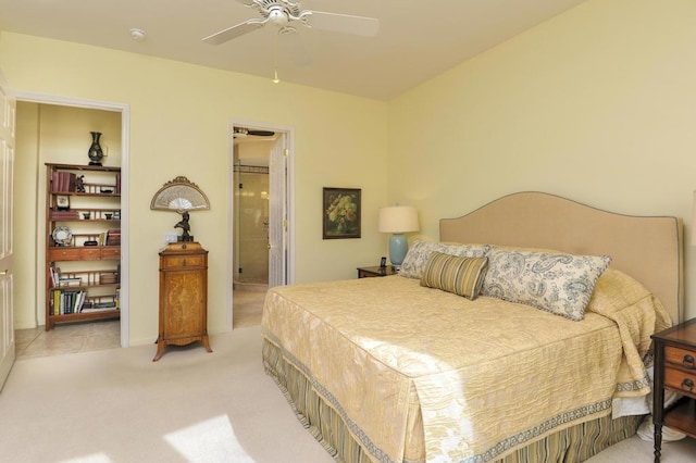 carpeted bedroom with ceiling fan and ensuite bath