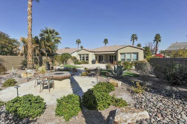 back of house featuring a patio area and a fire pit