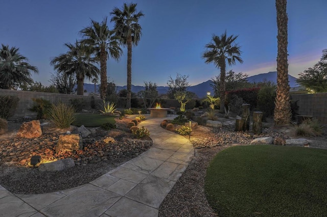 yard at dusk featuring a mountain view