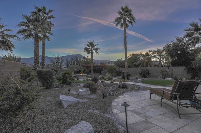 patio terrace at dusk featuring a mountain view