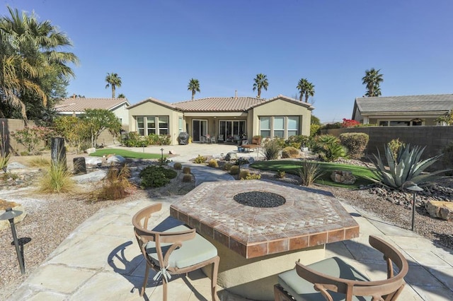 back of house with a patio and an outdoor fire pit