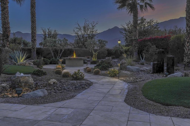 surrounding community with a mountain view, a patio area, and a fire pit