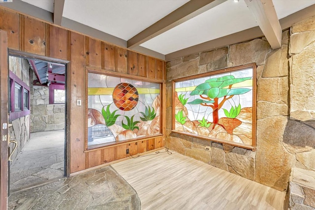 interior space featuring wooden walls, beam ceiling, and hardwood / wood-style floors