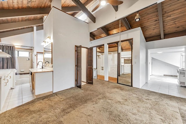 interior space featuring white cabinetry, lofted ceiling with beams, light colored carpet, and ceiling fan