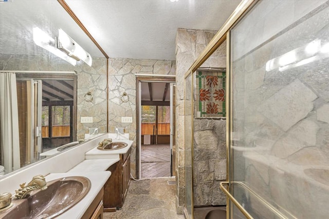 bathroom featuring a shower with door and vanity