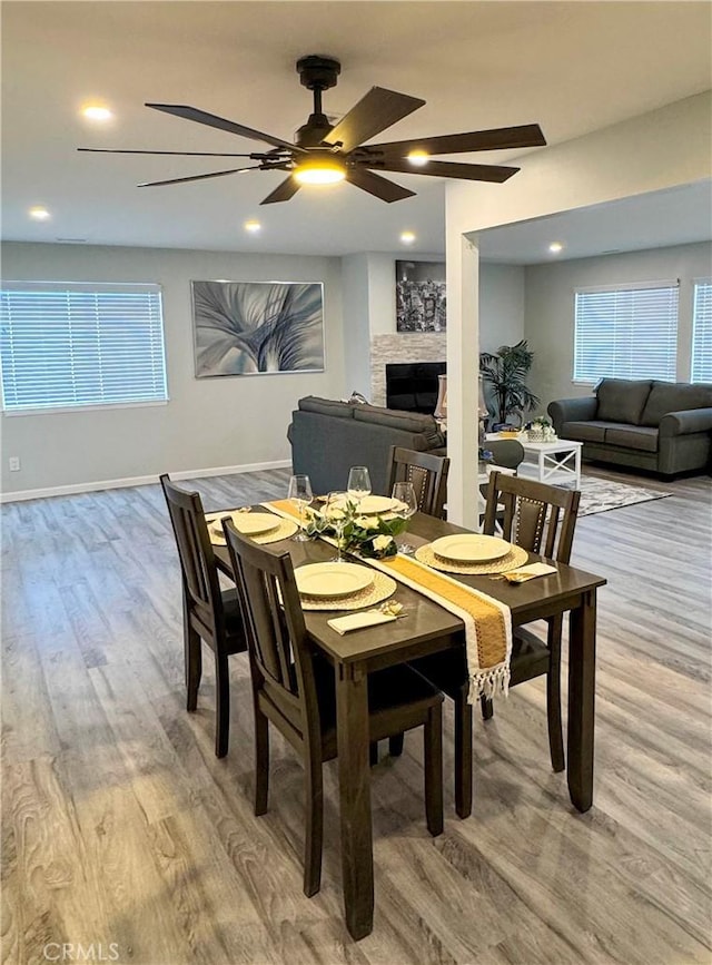 dining space with hardwood / wood-style floors and a fireplace