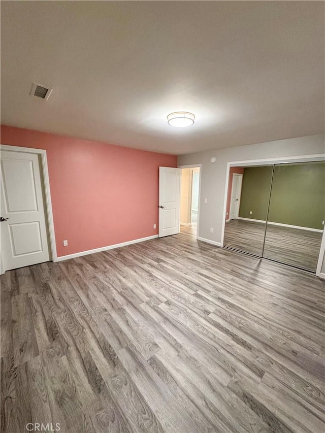 unfurnished bedroom featuring a closet and light hardwood / wood-style flooring