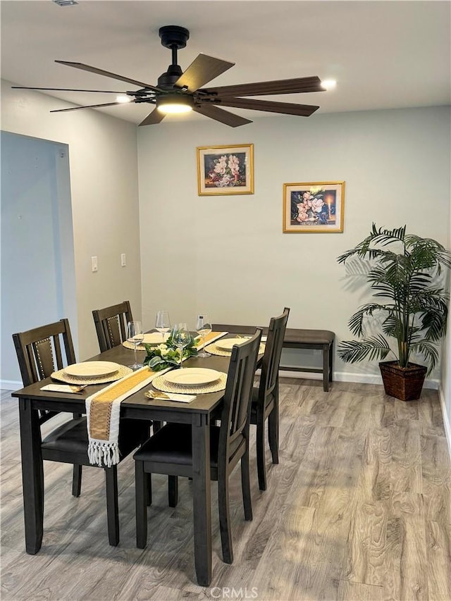 dining area with hardwood / wood-style flooring and ceiling fan