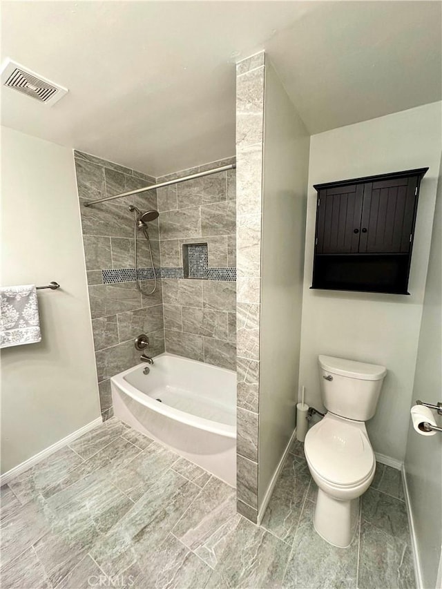 bathroom with tiled shower / bath and toilet