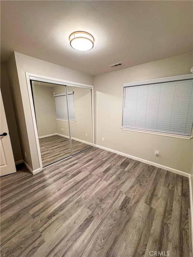 unfurnished bedroom with hardwood / wood-style floors and a closet