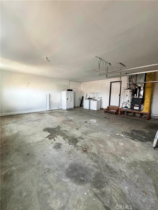 garage with gas water heater, white refrigerator with ice dispenser, and washing machine and dryer