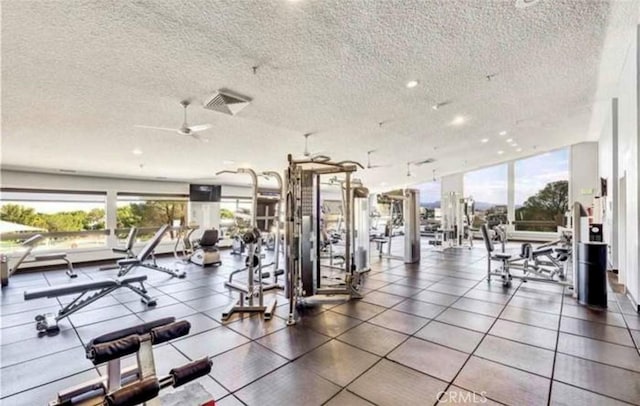 gym with ceiling fan and a textured ceiling