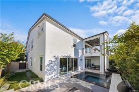 rear view of property featuring a patio, a balcony, and a jacuzzi