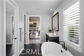 bathroom featuring hardwood / wood-style floors, vanity, and a bath