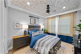 bedroom featuring ornamental molding and light wood-type flooring