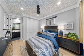 bedroom featuring crown molding, a closet, and light hardwood / wood-style flooring