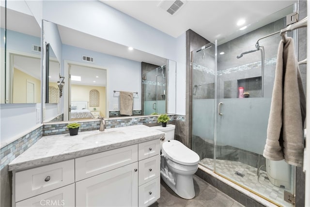 bathroom featuring vanity, decorative backsplash, a shower with shower door, and toilet