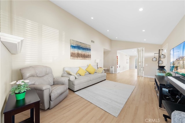 living room with vaulted ceiling and light wood-type flooring