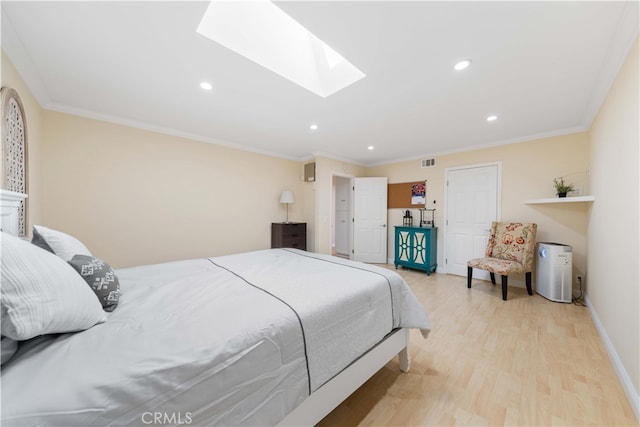 bedroom featuring crown molding, a skylight, and light hardwood / wood-style flooring