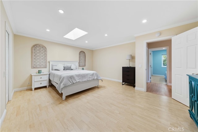 bedroom with crown molding, a skylight, and light hardwood / wood-style floors