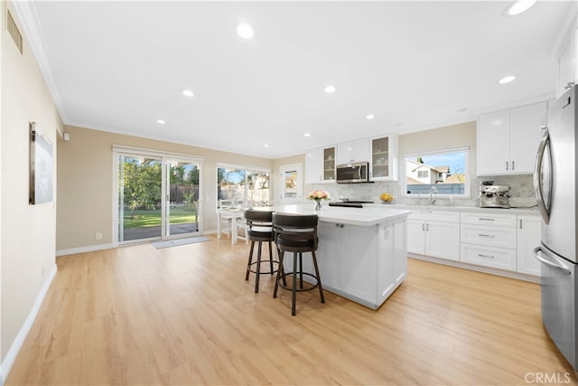 kitchen with sink, a center island, white cabinets, and appliances with stainless steel finishes