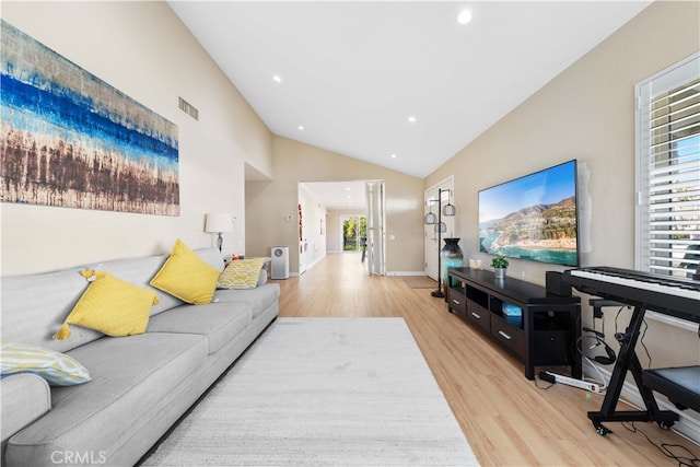 living room with high vaulted ceiling and light wood-type flooring