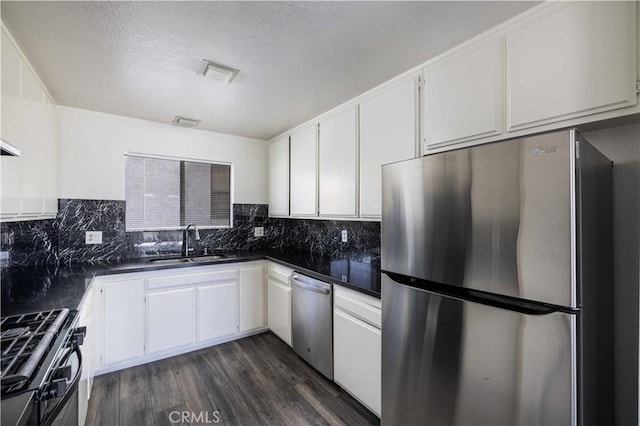 kitchen with dark hardwood / wood-style flooring, sink, white cabinets, and appliances with stainless steel finishes